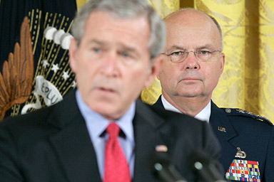 CIA Director Michael Hayden, right, looks on as President Bush speaks before signing the Military Commissions Act of 2006 which sets new standards expediting the interrogation and prosecution of terror suspects during a ceremony in the East Room of the White House in Washington, Tuesday, Oct. 17, 2006.
