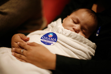 Nuhkon Shendo-Smith, four months old, sleeps in his mother's arms bundled in a blanket bearing a sticker supporting Democratic presidential candidate Barack Obama during a summit on the economy attended by Obama in Albuquerque, New Mexico February 1, 2008.