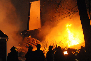 Firefighters are seen at the site of the wreckage of a plane, a Continental Connection flight operated by Colgan Air, which crashed in Clarence, near Buffalo, New York February 13, 2009.