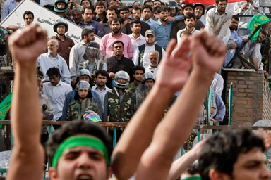 Supporters of leading opposition presidential candidate Mir Hossein Mousavi taunt members of the pro-government Basiji militia, seen in background, as the demonstration passes one of their bases, as hundreds of thousands of Mousavi supporters, who claim there was voting fraud in Friday's election, turn out to protest the result of the election at a mass rally in Azadi (Freedom) square in Tehran, Iran, Monday, June 15, 2009.