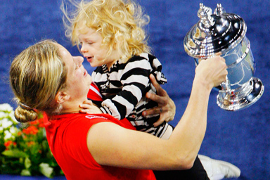 Kim Clijsters of Belgium carries her daughter Jada as she holds the trophy after defeating Caroline Wozniacki of Denmark in the women's singles final match at the U.S. Open tennis tournament in New York, September 13, 2009.