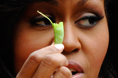 U.S. first lady Michelle Obama holds a bean harvested from vegetables grown in her garden at the White House in Washington June 16, 2009