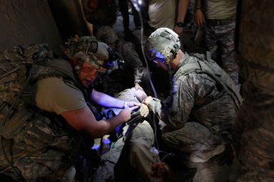 A wounded U.S. soldier receives first aid inside a bunker in the village of Bargematal, Nuristan province, August 25, 2009.