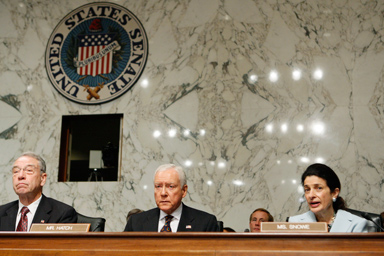 Senate Finance Committee member Sen. Olympia Snowe, R-Maine, right, says "aye" during a roll call vote as she sits with the committee's ranking Republican Sen. Charles Grassley, R-Iowa, left, and Sen. Orrin Hatch, R-Utah, on Capitol Hill in Washington, Tuesday, Oct. 13, 2009, as the committee voted regarding health care reform bill.