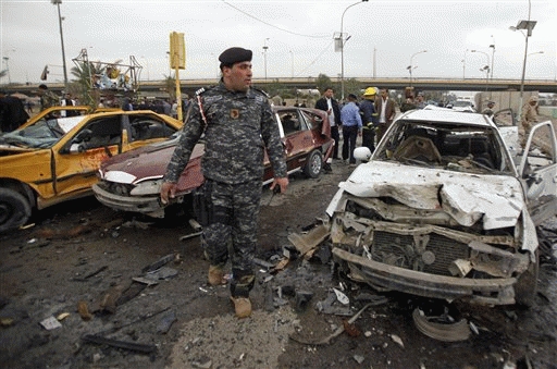 An Iraqi policeman inspects the site of a bomb attack near the Labor Ministry building in Baghdad, Iraq, Tuesday.