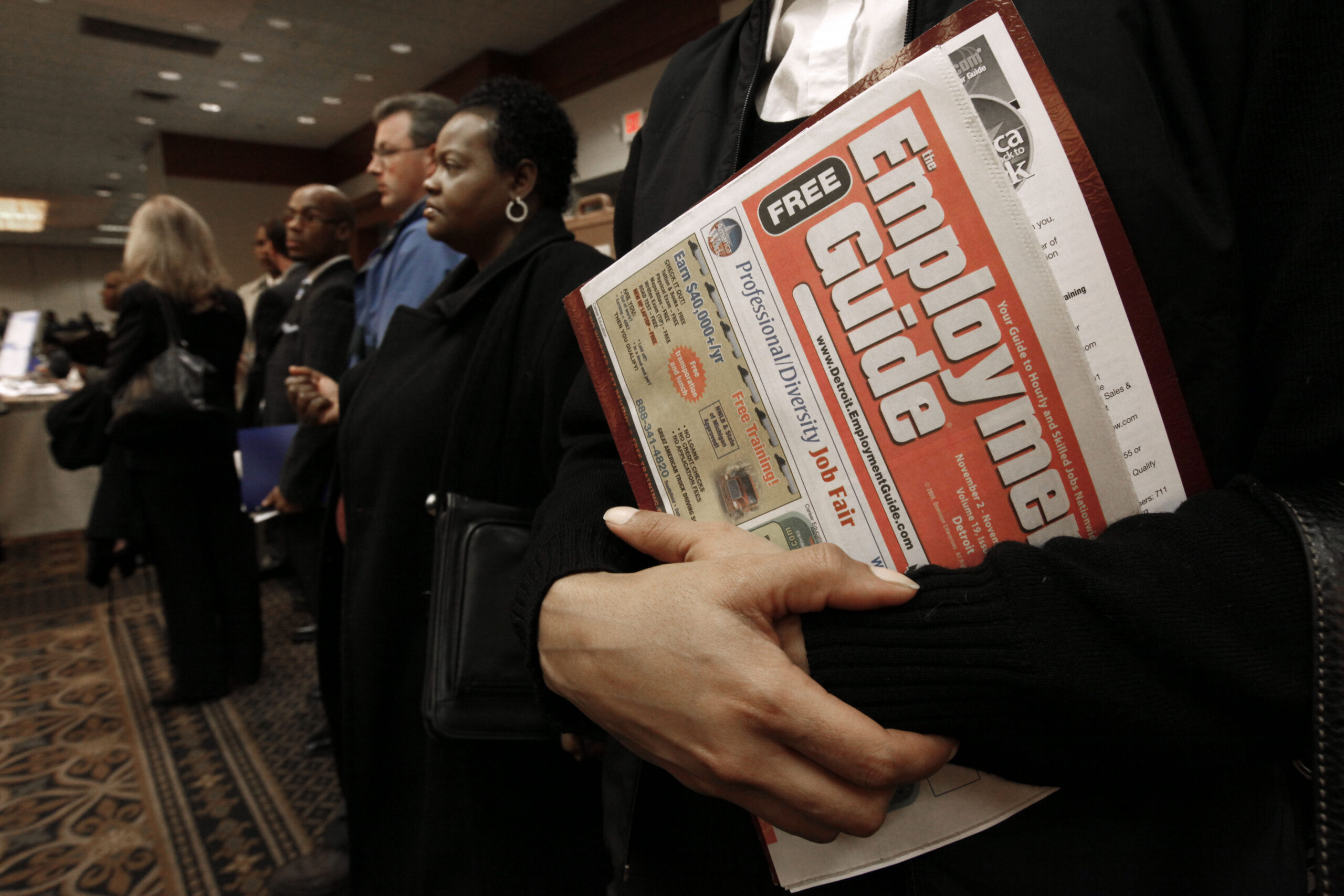 Sonja Jackson, of Detroit, holds a Employment Guide  standing in line while attending a job fair in Livonia, Mich., Wednesday, Nov. 4, 2009.   (AP Photo/Paul Sancya) (Paul Sancya)