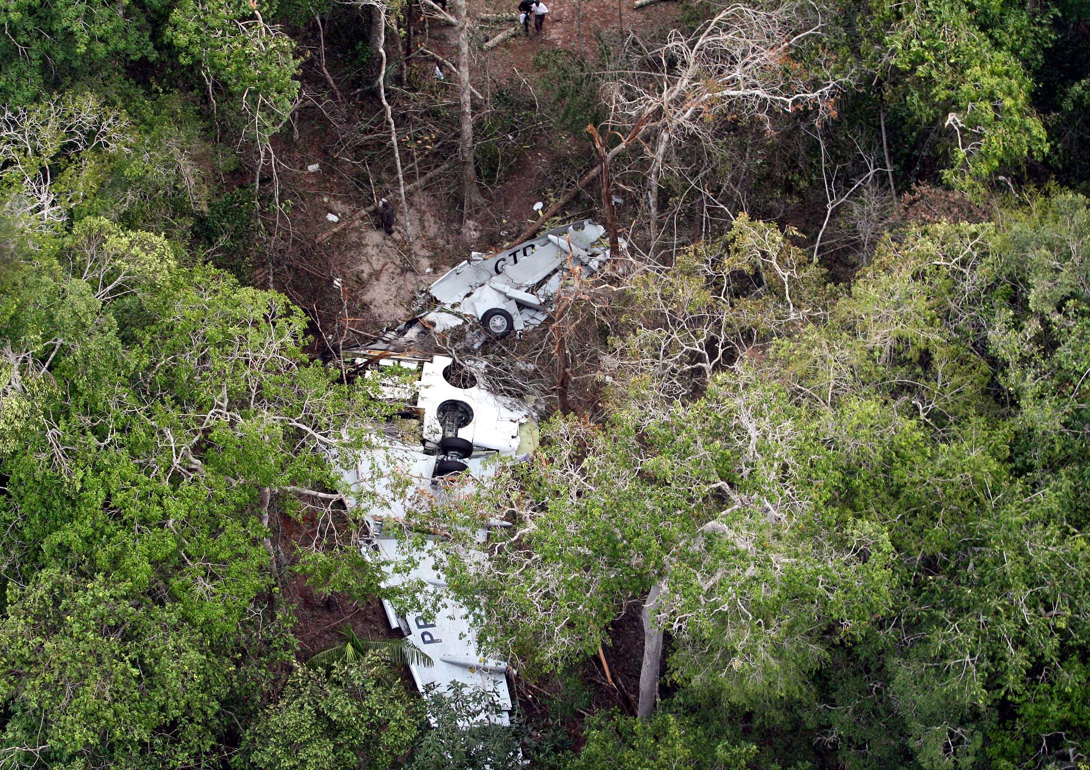 Part of the fuselage of the Gol airlines Boeing 737-800 that crashed in the jungle after clipping an Embraer Legacy 600XL executive jet last Friday, lies on the jungle floor at the Jarina Indian reserve in the Brazilian Amazon basin October 1, 2006. Rescuers recovered the first two bodies from the wreckage of the crashed Brazilian passenger plane in the Amazon jungle on Sunday and reported that none of the 155 people on board had survived, the Brazilian Airforce said.  REUTERS/Jamil Bittar  (BRAZIL) (Reuters)