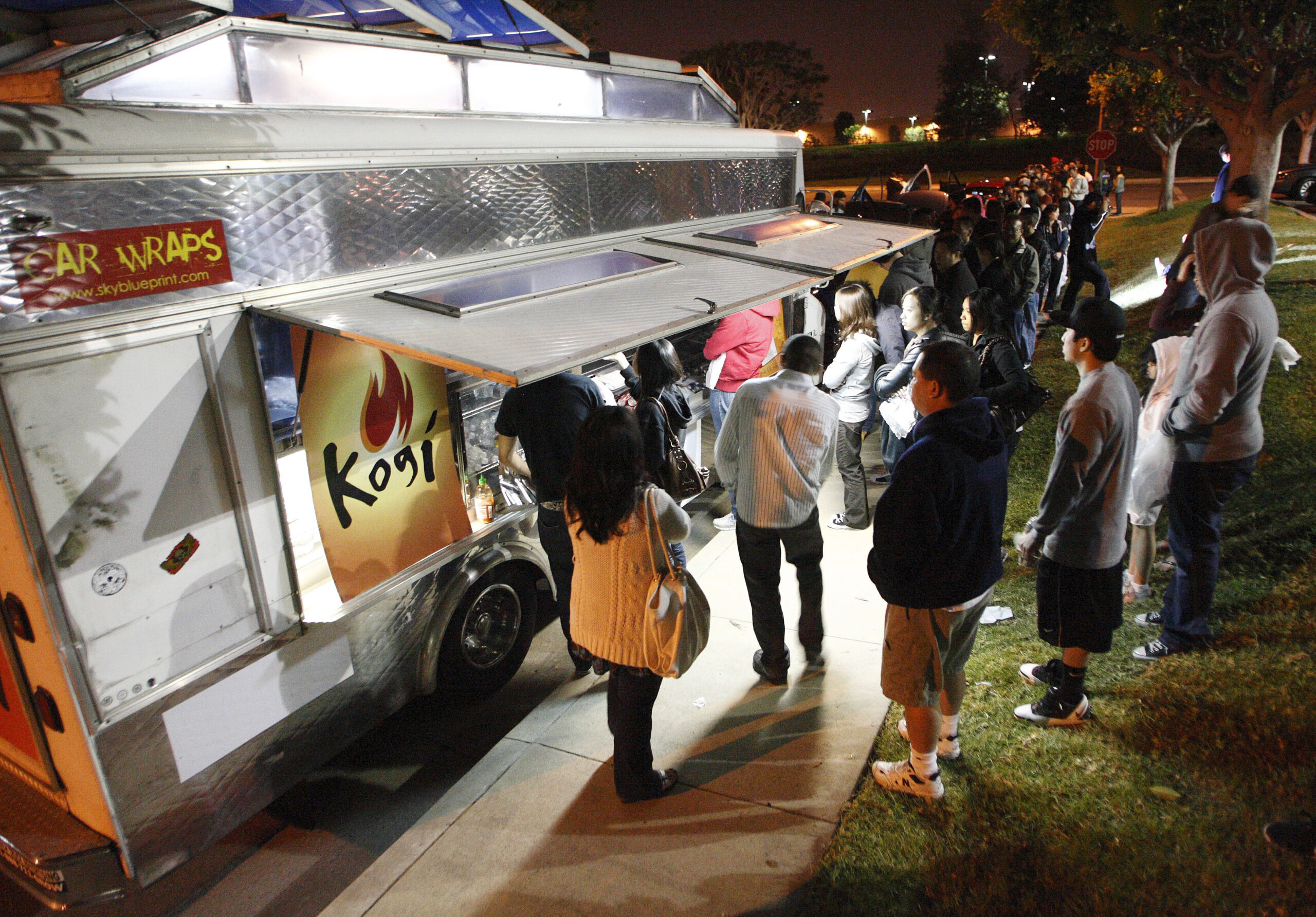 People wait for their food as others line up to place their orders at Kogi, a Korean BBQ-inspired taco truck, in Torrance, California, April 17, 2009. Kogi BBQ uses the online social networking site "Twitter" to alert followers to their location around the Los Angeles area and any other updates.  REUTERS/Danny Moloshok (UNITED STATES BUSINESS FOOD DRINK) (Reuters)