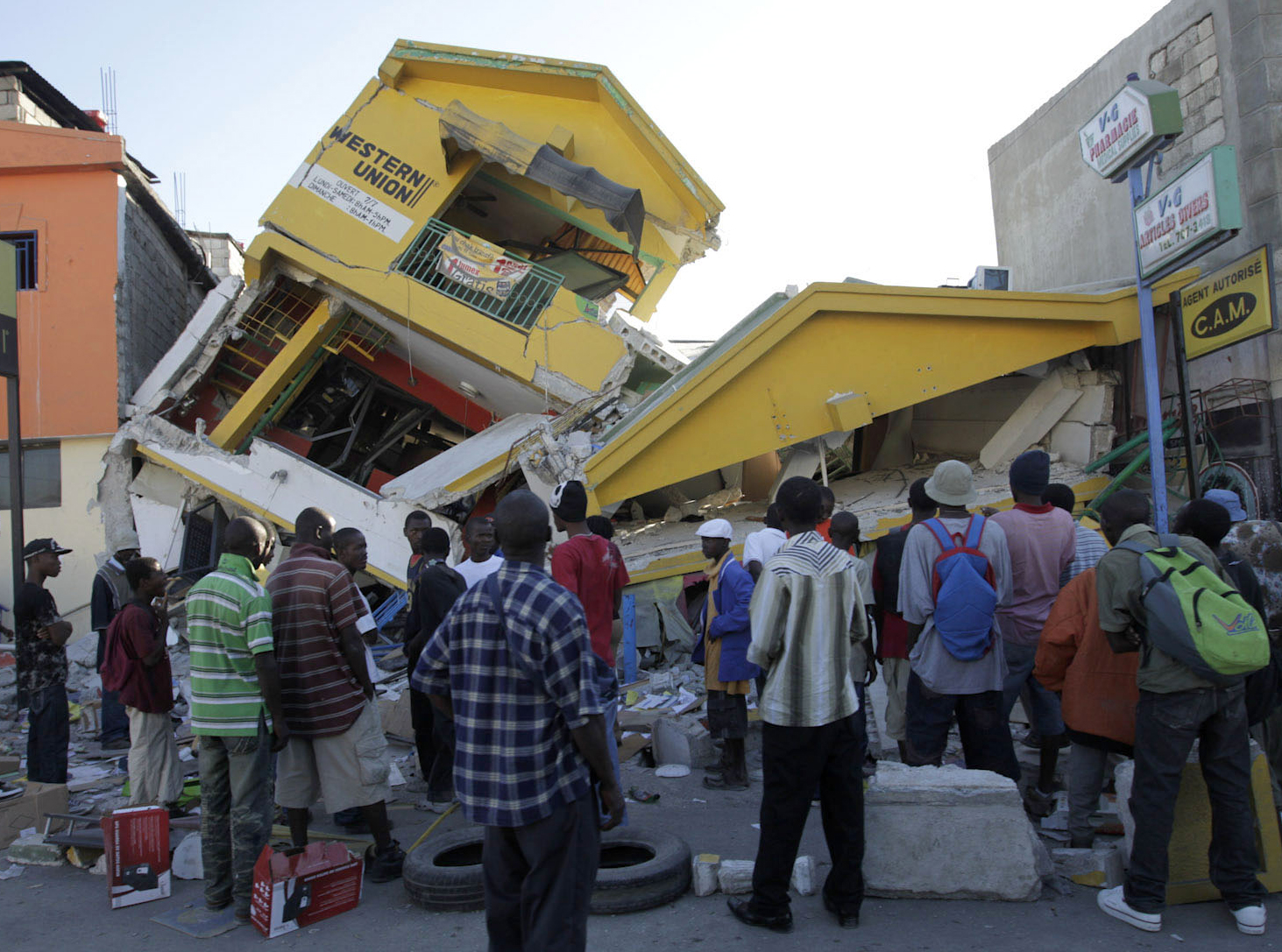 People look at a destroyed building in Port-au-Prince January 14, 2010. The death toll from Haiti's earthquake could be between 45,000 and 50,000, with a further three million people hurt or homeless, a senior Haitian Red Cross official said on Thursday.  REUTERS/Jorge Silva (HAITI - Tags: DISASTER IMAGES OF THE DAY) (Reuters)