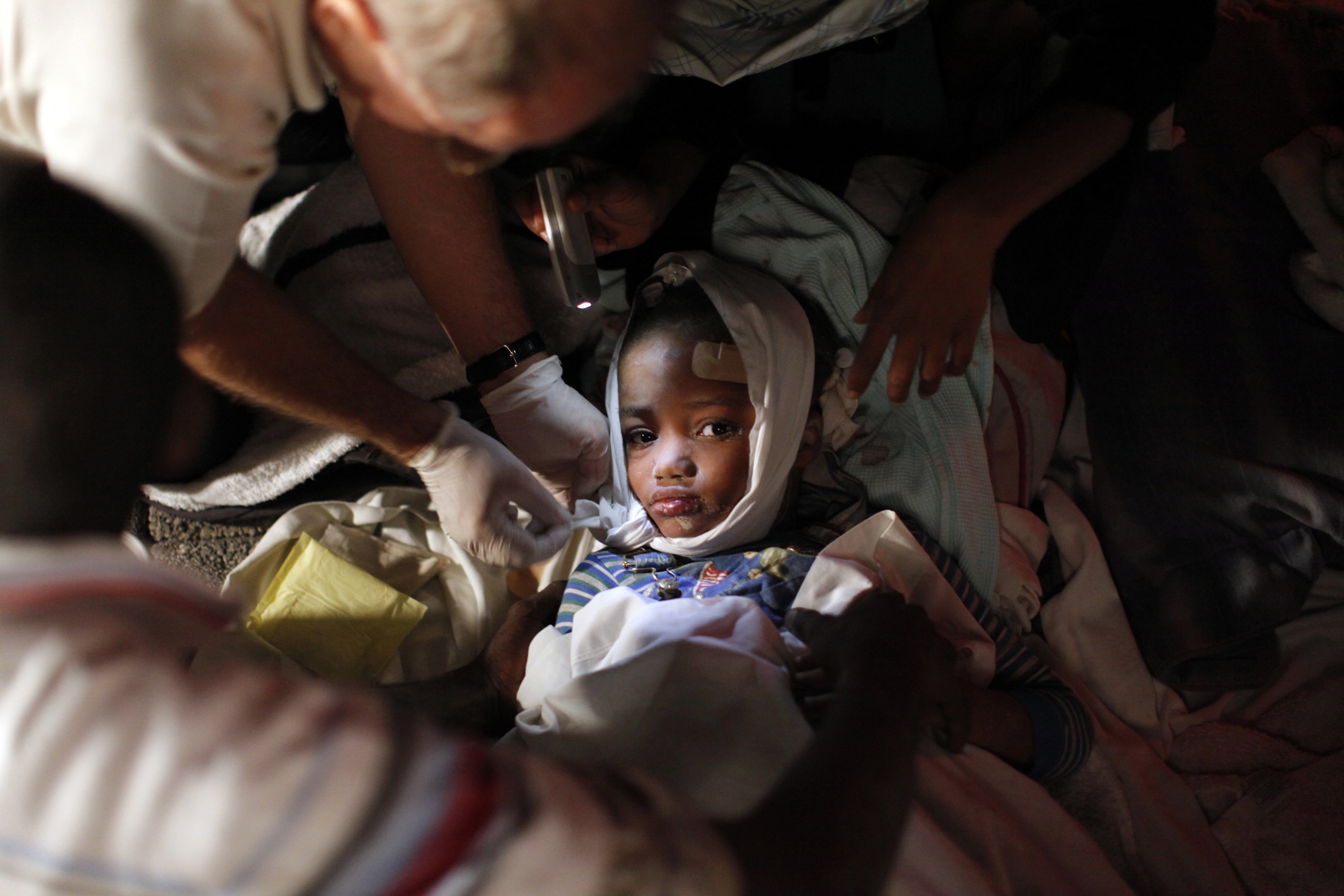 A injured child receives medical treatment after an earthquake in Port-au-Prince January 13, 2010. The  7.0 magnitude quake rocked Haiti, killing possibly thousands of people as it toppled the presidential palace and hillside shanties alike and leaving the poor Caribbean nation appealing for international help. REUTERS/Eduardo Munoz (HAITI tags: - Tags: DISASTER ENVIRONMENT IMAGES OF THE DAY) (Reuters)