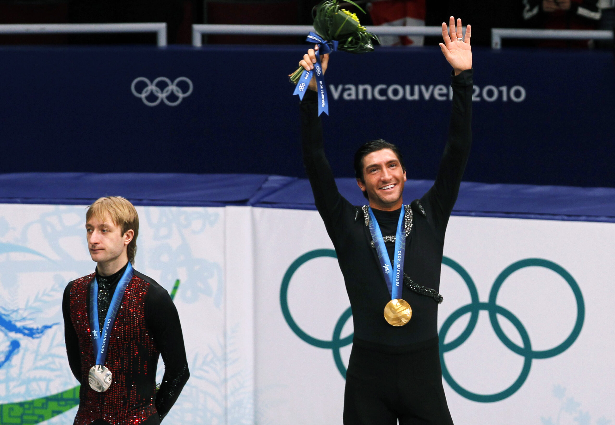 Gold medallist Evan Lysacek (R) of the U.S. waves as he stands next to silver medallist Yevgeny Plushenko of Russia during the medal ceremony after the men's free skating figure skating competition at the Vancouver 2010 Winter Olympics February 18, 2010. Russian Prime Minister Vladimir Putin climbed into the controversy surrounding Plushenko's surprise defeat in the Olympics figure skating by claiming on Friday that he should have been awarded gold. Picture taken February 18, 2010.    REUTERS/David Gray (CANADA) (Reuters)