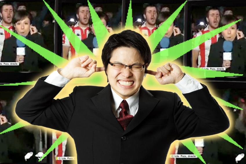 A businessman covering his ears with his fingers