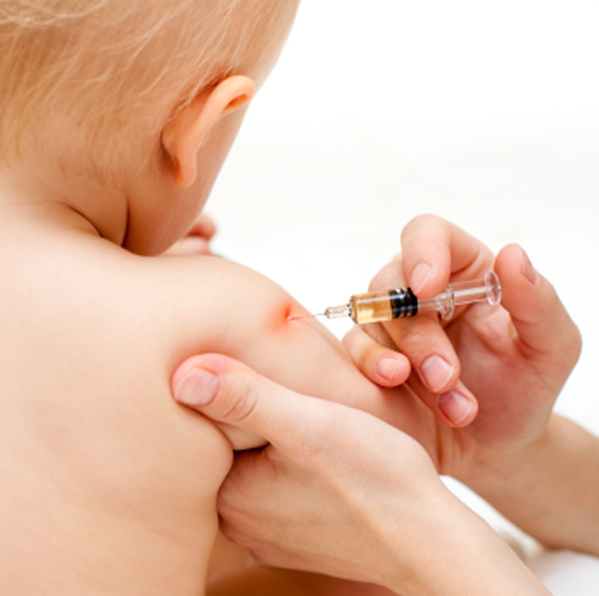 Doctor giving a child an intramuscular injection in arm, shallow DOF (Dmitry Naumov)
