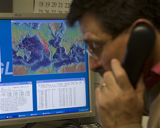 With a computer graphic showing the possible path of tsunami waves from an earthquake in Chile, Dr. Charles McCreery speaks on the phone at the Pacific Tsunami Warning Center, Saturday, Feb. 27, 2010 in Ewa Beach, Hawaii.  The State of Hawaii is under a tsunami warning after an 8.8 magnitude earthquake rattled Chile today.  (AP Photo/Marco Garcia) (AP)