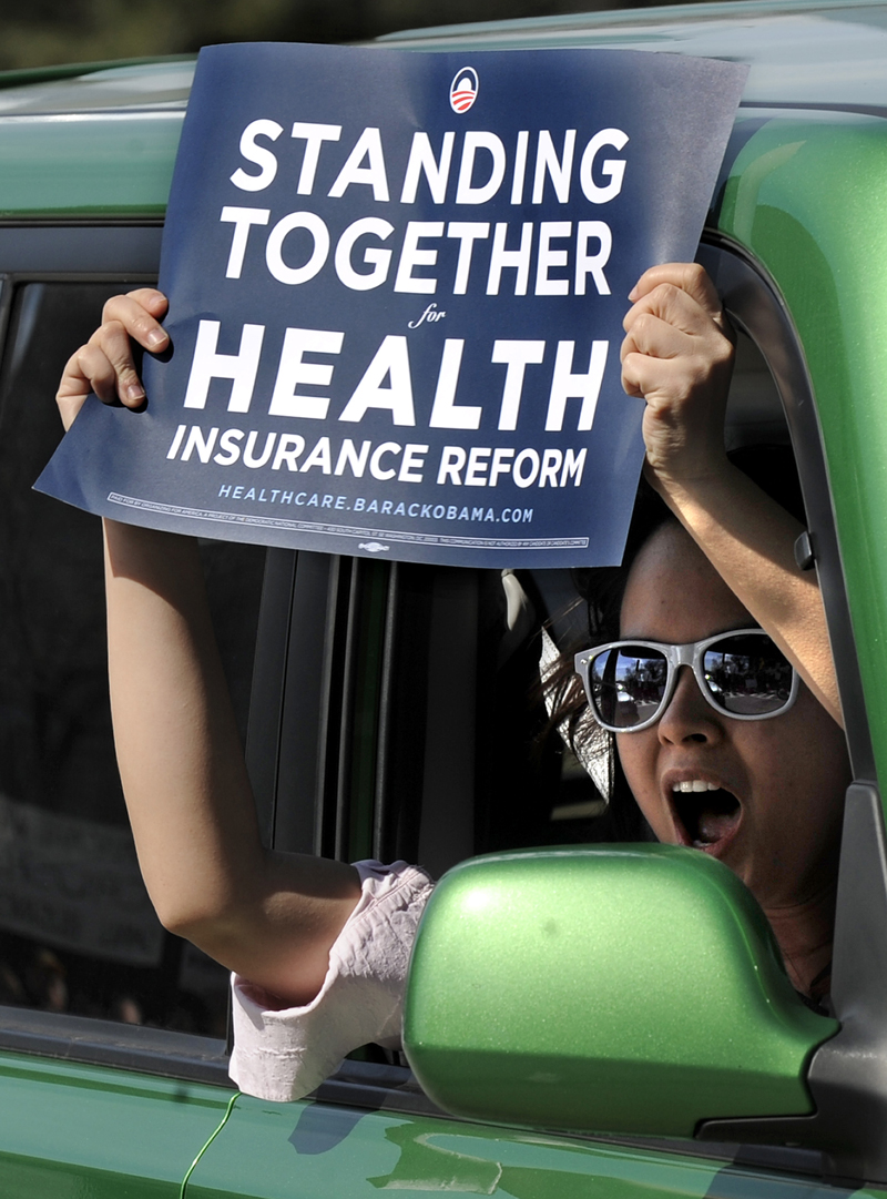 A passerby yells in support of health care during a tea party protest against the proposed health care plan outside Congresswoman Melissa Bean's office in Schaumburg, Ill., Tuesday, March 16, 2010.  (AP Photo/Paul Beaty) (Paul Beaty)