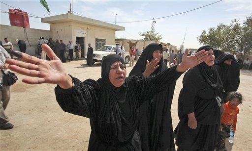 The mother, center-left, of Fayha Kadim, 23, and Fayha's son Muntadhar Waleed, 3, who were both killed in blasts in northeastern Baghdad Sunday, grieves at their funeral in Najaf, Iraq, Monday, March 8, 2010, while her finger still bears the ink of those who voted.  The election day's death toll was 36, with various incidents of rockets and mortars, hand grenades and bombs all being used to target polling stations and the people voting. (AP Photo/Alaa al-Marjani) (AP)