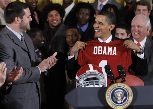 President Barack Obama smiles as he holds an University of Alabama football jersey during a ceremony honoring the BCS national champion Crimson Tide football team, Monday, March 8, 2010, in the East Room of the White House in Washington. (AP Photo/Alex Brandon) (AP)