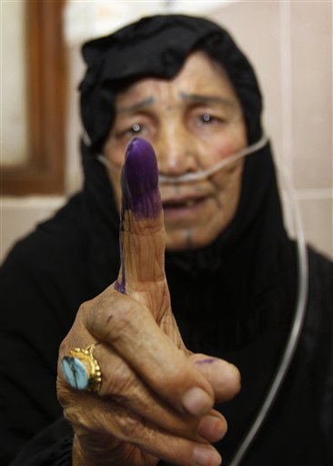 Hospital patient Coka Khudhyer, 72, attached to an oxygen tube, displays her inked finger after casting her vote at Al-Fayha hospital in Basra, Iraq, Thursday, March 4, 2010. Early voting in Iraq for detainees, hospital patients and military and security personnel is taking place Thursday, ahead of the parliamentary elections on Sunday, March 7, 2010. (AP Photo/Nabil al-Jurani) (AP)
