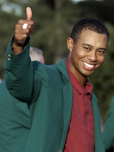 FILE - In this April 14, 2002, file photo, Tiger Woods, wearing his green jacket, gives a thumbs up as he celebrates winning the Masters golf tournament at the Augusta National Golf Club in Augusta, Ga.  In a statement Tuesday, March 16, 2010, Woods said he will play at Augusta National after a four-month hiatus because of a sex scandal. The Masters begins on April 8. (AP Photo/Elise Amendola, File) (AP)