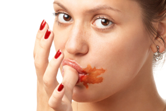 portrait of sexy young girl licking her thumb with bar of chocolate; isolated on white (Pavel Sazonov)