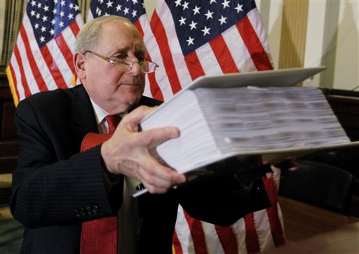 Senate Investigations subcommittee Chairman Sen. Carl Levin, D-Mich., lifts a binder of exhibit documents on the role of investment banks on the Wall Street financial crisis, as he briefs reporters on Capitol Hill in Washington, Monday, April 26, 2010, ahead of the Goldman Sachs hearings. (AP Photo/Charles Dharapak) (AP Photo/Charles Dharapak) (AP)