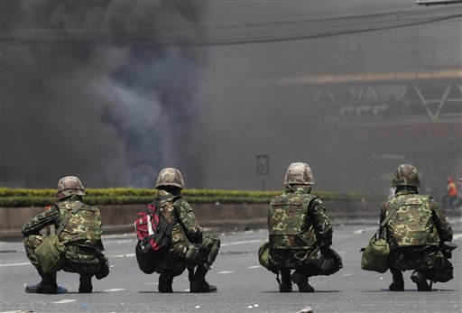 Thai soldiers take position against black smoke as anti-government protesters burned tires in downtown Bangkok, Thailand, Friday, May 14, 2010. Thai troops fired bullets and tear gas at anti-government protesters rioting near the U.S. and Japanese embassies Friday as an army push to clear the streets sparked deadly clashes and turned central Bangkok into a virtual war zone.(AP Photo/Wason Wanichakorn) (AP)