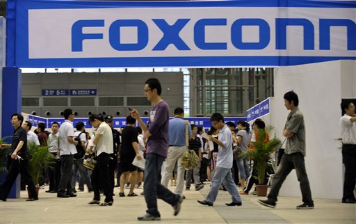 In this photo taken on May 22, 2010, visitors to a job fair walk past the Foxconn recruitment area in Shenzhen in south China's Guangdong province. (AP)