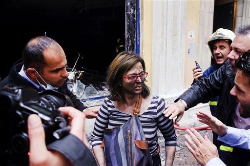 A bank employee reacts after being rescued from a fire that broke out when the bank was attacked during anti-government protests in central Athens, Wednesday, May 5, 2010. Three people died in the fire at the branch of Marfin Egnatia Bank, while the two women and two others were rescued. An estimated 100,000 people took to the streets Wednesday during a nationwide wave of strikes against spending cuts aimed at saving the country from bankruptcy  (AP Photo/Iakovos Hatzistavrou) ** GREECE OUT ** (AP)