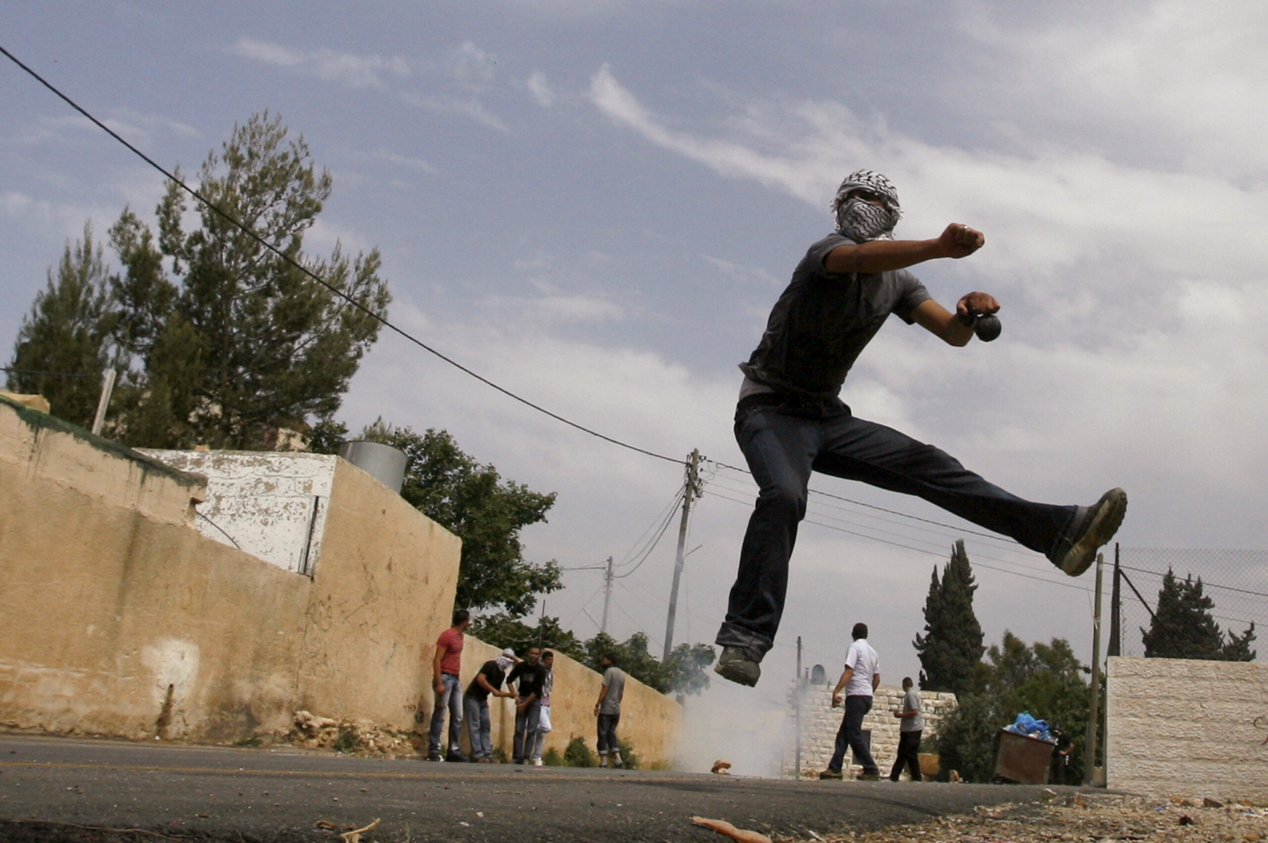 A Palestinian throws a stone towards Israeli border police during clashes in the West Bank village of Nabi Saleh near Ramallah April 16, 2010. Israeli border police used tear gas and rubber bullets to disperse Palestinian protesters and Israeli activists during a violent protest over a land dispute with Jewish settlers in the area. REUTERS/Mohamad Torokman (WEST BANK - Tags: POLITICS CIVIL UNREST IMAGES OF THE DAY) (Reuters)