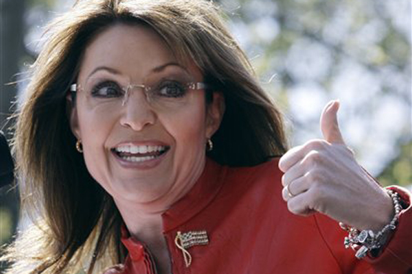 FILE - In this April 14, 2010  file photo, Sarah Palin flashes a thumbs up towards her husband Todd as she begins to address a crowd during a stop of the Tea Party Express on Boston Common in Boston. Sarah Palin could have hardly picked a more liberal town than Eugene to give a speech. The university town has been a hotbed of radical activity over the years, from the Vietnam War to environmental activism. But Palin is the headliner at a Republican Party fundraiser Friday night. (AP Photo/Charles Krupa, File) (Charles Krupa)