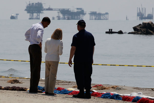 U.S. President Barack Obama, National Incident Commander U.S. Coast Guard Adm. Thad Allen and Lafourche Parish President Charlotte Randolph (C) survey damage along the Louisiana coastline at Fourchon Beach caused after a BP oil line ruptured in the Gulf of Mexico, May 28, 2010.