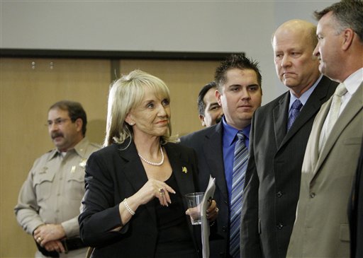 Arizona Gov. Jan Brewer walks past law enforcement members after she signed immigration bill SB1070 into law Friday, April 23, 2010, in Phoenix. The sweeping measure would make it a crime under state law to be in the country illegally, and would require local law enforcement to question people about their immigration status if there is reason to suspect they are in the country illegally. (AP Photo/Ross D. Franklin) (AP)