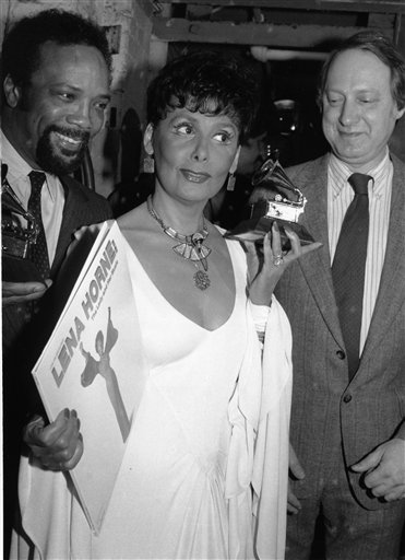FILE -- In a March 7, 1982 file photo Grammy Award winner Lena Horne, center, is flanked by record producer Quincy Jones, left, holding his Grammy, and Dan Morgenstern, of the National Academy of Recording Arts and Sciences, as she displays her award, and the record that earned it, in New York.  Singer Lena Horne, who broke racial barriers as a Hollywood and Broadway star famed for her velvety rendition of "Stormy Weather," has died at age 92.  (AP Photo/Ron Frehm/file) (AP)