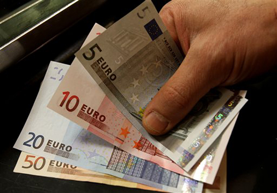 A customer receives euro notes in a counter at the Bank of Greece headquarters in Athens, Thursday, April 8, 2010. Greece's borrowing costs spiked higher for a third day Thursday, intensifying the country's debt crisis and suggesting a eurozone rescue program is providing little support. (AP Photo/Thanassis Stavrakis) (Thanassis Stavrakis)