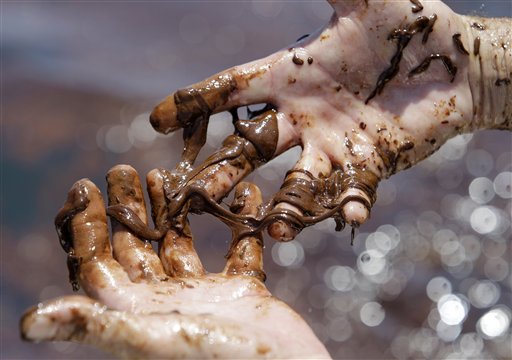Marine reef ecologist Scott Porter works to remove oil from the Deepwater Horizon spill off his hands, Monday, June 7, 2010, in the Gulf of Mexico south of Venice, La..  (AP Photo/Eric Gay) (AP)