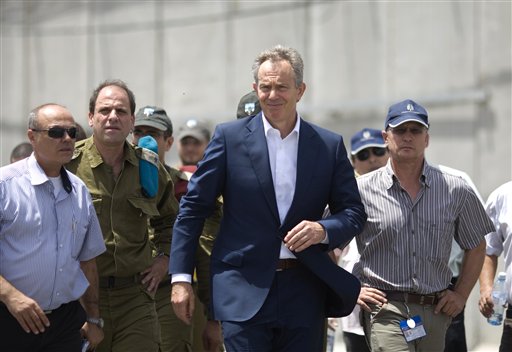 International Mideast envoy Tony Blair, center, visits the Kerem Shalom crossing, between Israel and the Gaza Strip, southern Israel, Tuesday, June 22, 2010. Israel announced Sunday an easement of its blockade on the Gaza strip saying it will allow almost all items into Gaza, except for weapons or weapons-related materials that could boost the area's militant Hamas rulers. Previously, Israel had issued only a narrow list of items to enter Gaza. (AP Photo/Ariel Schalit) (AP)