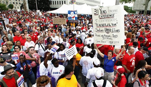 Thousands of people, some holding signs, fill the street near the New Jersey Statehouse during a rally Saturday, May 22, 2010, in Trenton, N.J., to protest Gov. Chris Christie's proposed budget cuts. Organizers say members of public employee unions hope a show of force will sway the state's top politicians to fight Christie. Gov. Christie has called for workers to accept wage freezes, and he's pushed for them to contribute toward their health benefits. (AP Photo/Mel Evans) (AP)