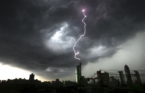 In this photo taken Monday, June 21, 2010, a lightning strikes the top of a building in Foshan in south China's Guangdong province. On Tuesday, President Hu Jintao and Premier Wen Jiabao have called for stepped-up rescue efforts after torrential rains brought down a dike in southern China, forcing 68,000 people to flee their homes. (AP Photo) ** CHINA OUT ** (AP)