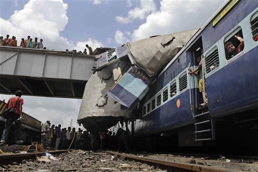 The roof of Uttarbanga Express's passenger car sits on top of Vananchal Express as rescue workers search for survivors at the site of an accident at Sainthia station, about 125 miles (200 kilometers) north of Calcutta, India, Monday, July 19, 2010. The speeding Uttarbanga Express train collided with stationary Uttarbanga Express at the station in eastern India early Monday, mangling the carriages and killing scores of people, railway police said. (AP Photo/Bikas Das) (AP)