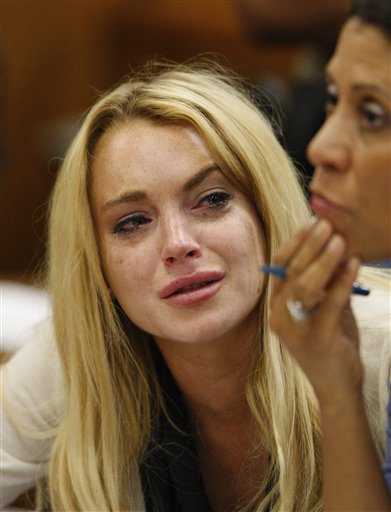 Actress Lindsay Lohan, left, reacts with her attorney Shawn Chapman Holley after the sentencing by Superior Court Judge Marsha Reve during a hearing in Beverly Hills, Calif., Tuesday, July 6, 2010. The judge sentenced Lindsay Lohan to 90 days in jail Tuesday after ruling she violated probation in a 2007 drug case by failing to attend court-ordered alcohol education classes. (AP Photo/David McNew, Pool) (AP)