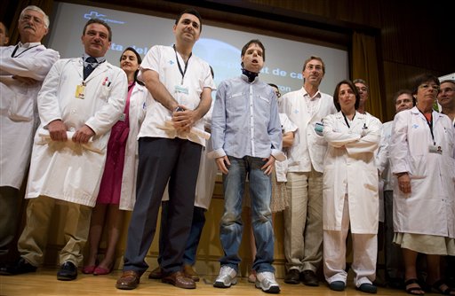 Oscar,center, a man who underwent a full-face transplant in April, poses beside Dr. Joan Barret, fourth from left, and surrounded by doctors as he appears in public for the first time in a news conference at the Vall d'Hebron Hospital in Barcelona, Spain, Monday, July 26, 2010. A 30-member medical team led by the Spanish doctor Juan Barret carried out a full-face transplant, giving a young man who lost his in an accident a new nose, skin, jaws, cheekbones, teeth and other features. (AP Photo/David Ramos) (AP)