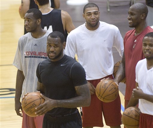 NBA free-agent LeBron James, foreground, is shown with Christian Eyenga, rear left, James friend Romeo Travis, white shirt, Jawad Williams, red shirt and Damon Jones, right, during a workout at the LeBron James Skills Academy for high school and college basketball players as a group of high school players watch, at Rhodes Arena on the University of Akron campus, in Akron, Ohio, Monday, July 5, 2010. (AP Photo/Phil Long) (AP)