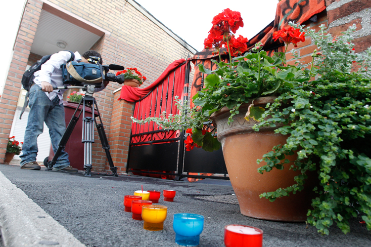 Candles are displayed in front of the house where the bodies of eight newborn children were found in northern France