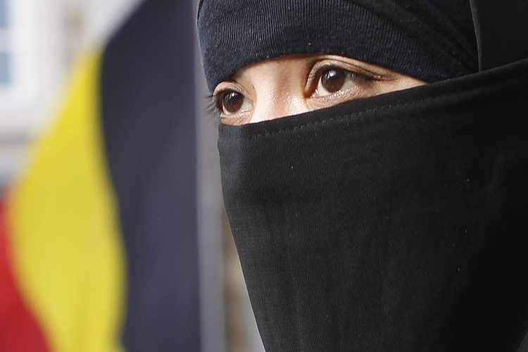 Salma, a 22-year-old French national living in Belgium who chooses to wear the niqab after converting to Islam, gives an interview to Reuters television outside the Belgian Parliament in Brussels April 26, 2010. Belgium's parliament is due to vote on a proposal to ban the wearing of the full veil and the the full outer garment, or burqa, after a Belgian parliamentary committee voted to ban the full Islamic face veil. If ratified, Belgium could be the first country in Europe to enforce such a ban. Photo taken April 26, 2010.   REUTERS/Yves Herman    (BELGIUM - Tags: RELIGION POLITICS) (Â© Yves Herman / Reuters)