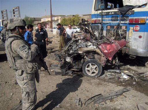 A U.S. Army soldier and Iraqi police stand at the site of a bombing in Kirkuk, 290 kilometers (180 miles) north of Baghdad, Iraq, Wednesday, Aug. 25, 2010. A string of attacks targeting Iraqi security forces on Wednesday left several people dead and scores wounded, police and hospital officials said the day after the number of American soldiers in the country fell bellow 50,000.(AP Photo/Emad Matti) (AP)