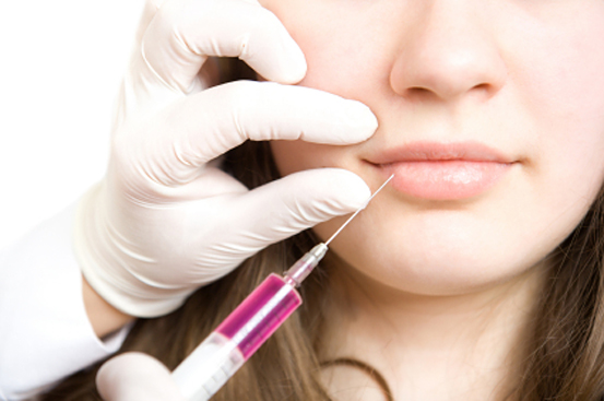 Doctor making injection in lips of young woman (Vadim Ponomarenko)