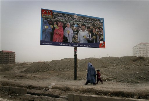 In this Monday, Aug. 23, 2010 photo, an Afghan woman walks with her son under an election billboard asking people to vote for upcoming parliamentarian election in Kabul, Afghanistan. Afghans will go to the polls for parliamentary elections in September. After a fraud-ridden presidential election last year that nearly undermined President Hamid Karzai's legitimacy and international support, the Sept. 18 parliamentary ballot is being watched closely as a test of whether the Afghan government is serious about reform. (AP Photo/Musadeq Sadeq) (AP)