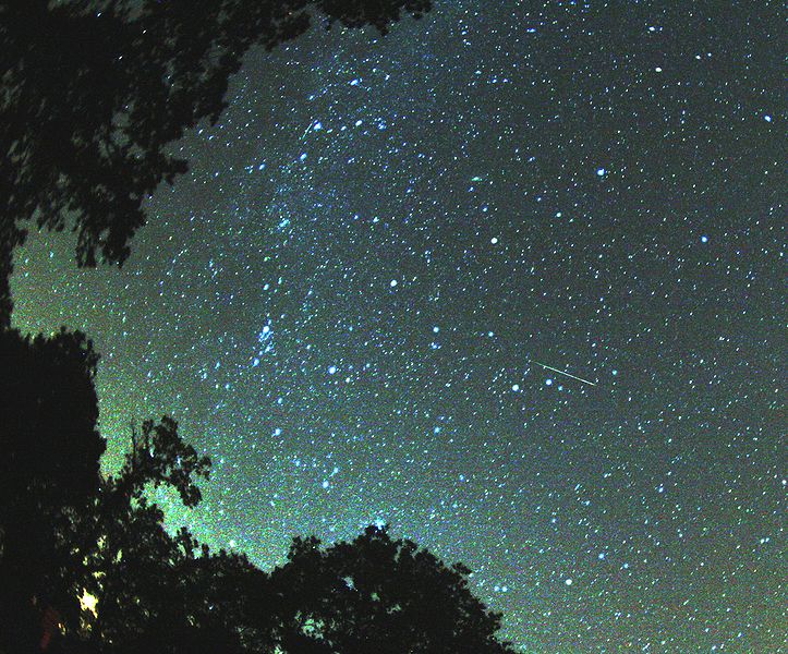 A multicolored Perseid meteor striking the sky just to the right from Milky Way.