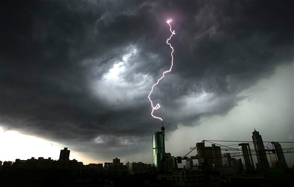 Lightning strikes the top of a building in Foshan in south China's Guangdong province in June. Torrential rains brought down a dike in southern China, forcing 68,000 people to flee their homes.