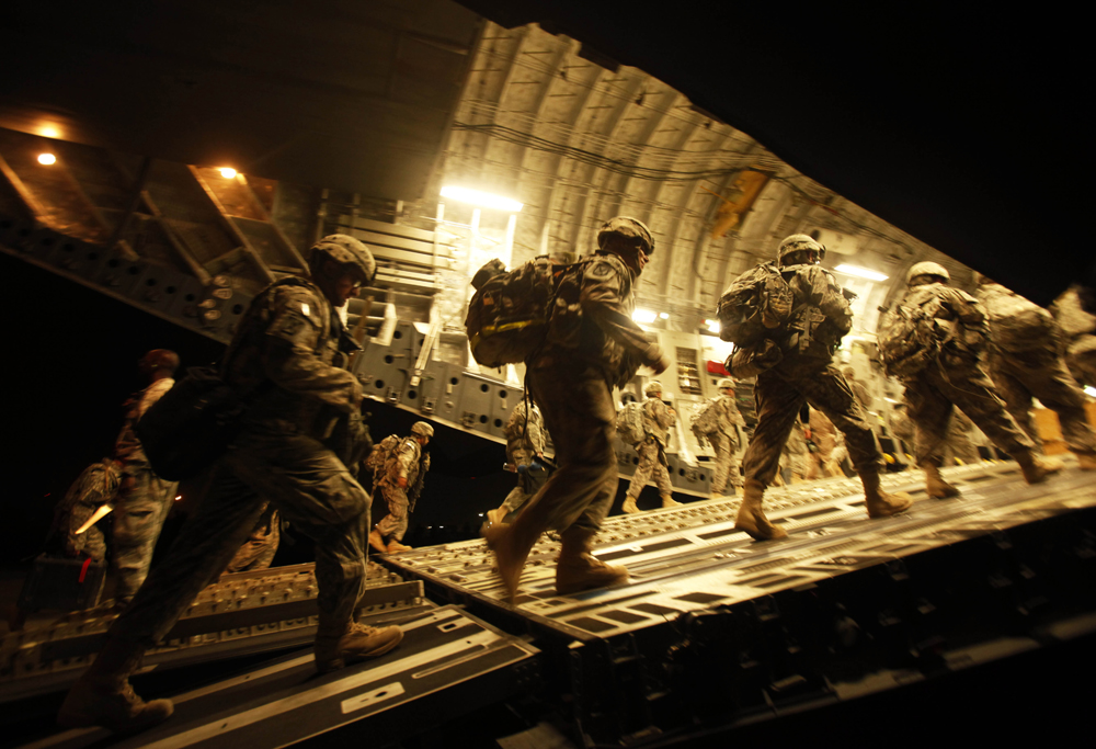FILE - In this Tuesday, July 13, file 2010 photo, U.S. Army soldiers from 2nd Brigade, 10th Mountain Division board a C-17 aircraft at Baghdad International Airport as they begin their journey to the United States. Everything from helicopters to printer cartridges are being wrapped and stamped and shipped out of Iraq in one of the most monumental withdrawal operations the American military has ever carried out as U.S. forces flow out of the country. The move is reversing, over the course of months, a U.S. military presence that built up over seven years and dug in so deep it once seemed immovable. More than 400 bases are being closed down or handed over to the Iraqi military, some closer to small towns with elaborate dining facilities serving tacos and crab legs and gyms with rows of treadmills.(AP Photo/Maya Alleruzzo, File) (Maya Alleruzzo)